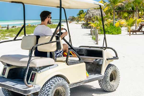 Tourist driving a golf cart on teh beach